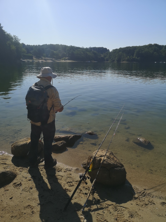 Pêcheur au bord d’un lac du Cantal lors d’une sortie de pêche avec OP Fishing